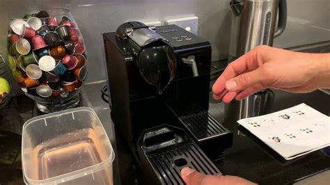 Pour the collected liquid back into the water tank. . Nespresso descaling video
